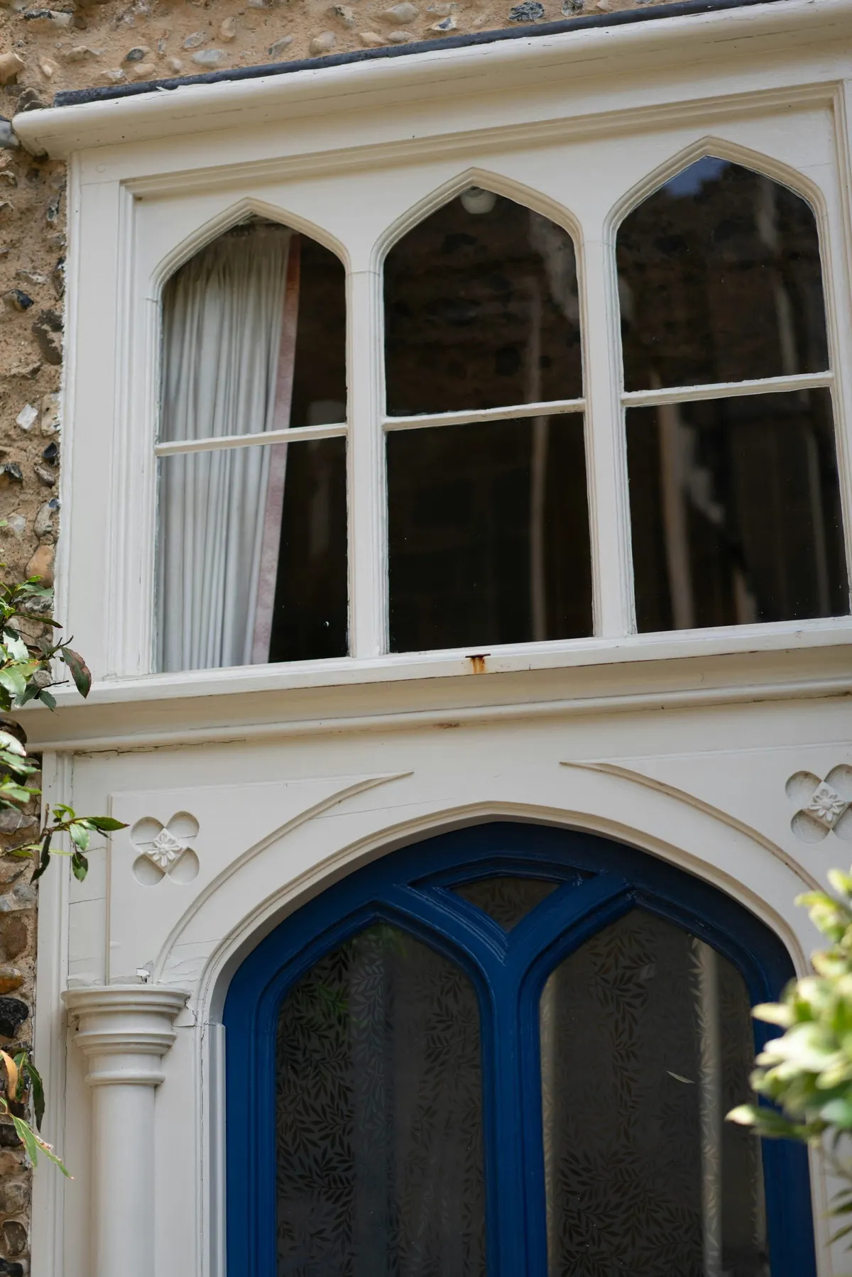 Gothic arched window tracery above a painted door