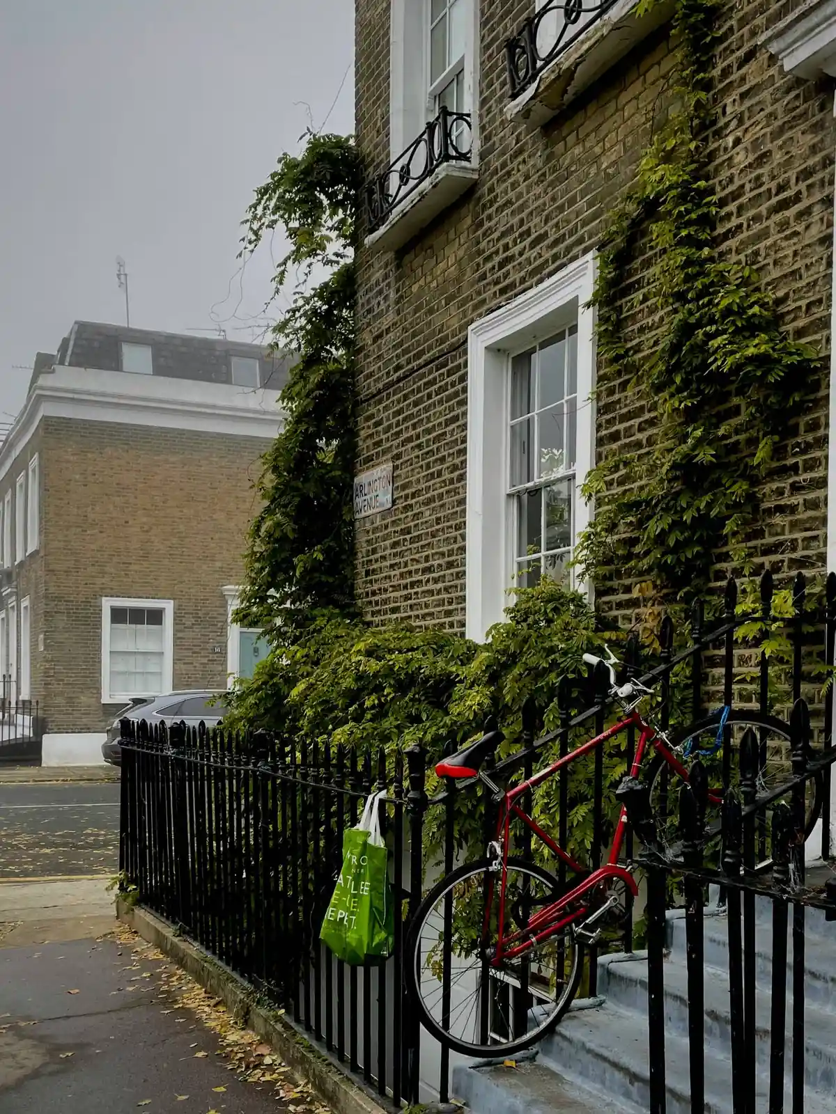 A brick frontage behind iron railings