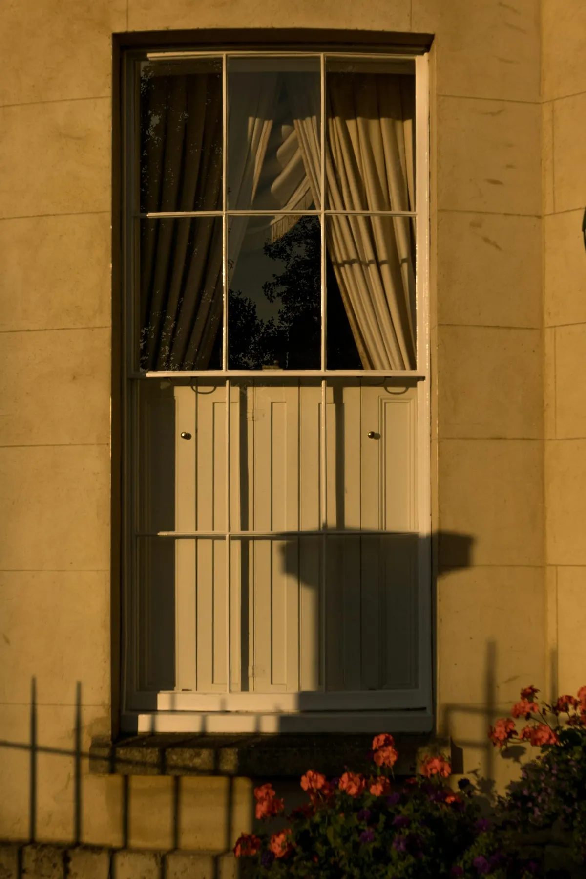 Window shadow falling across an ochre plastered wall