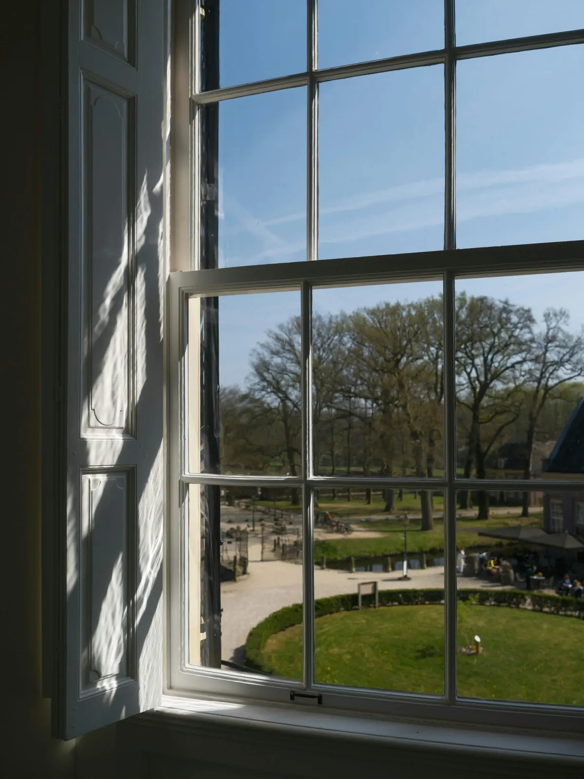 A multi-pane window looking onto parkland